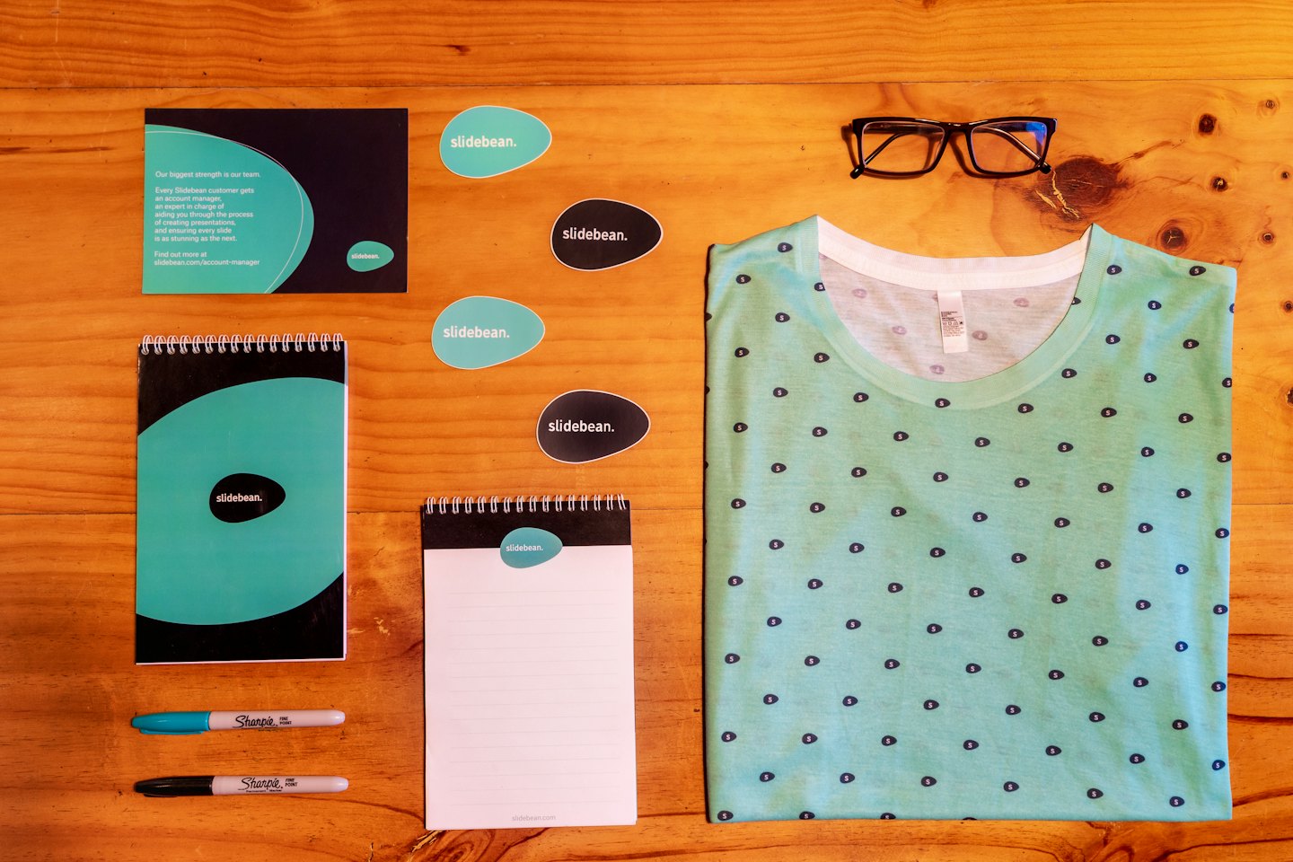 Branded merchandise arranged on a light brown wooden surface.