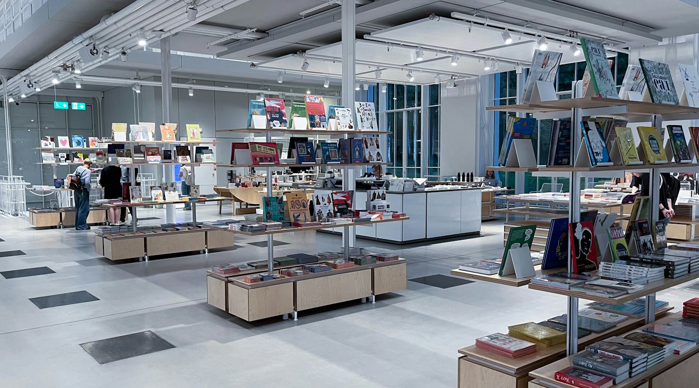 Customers browse books and gifts in a spacious, modern shop.