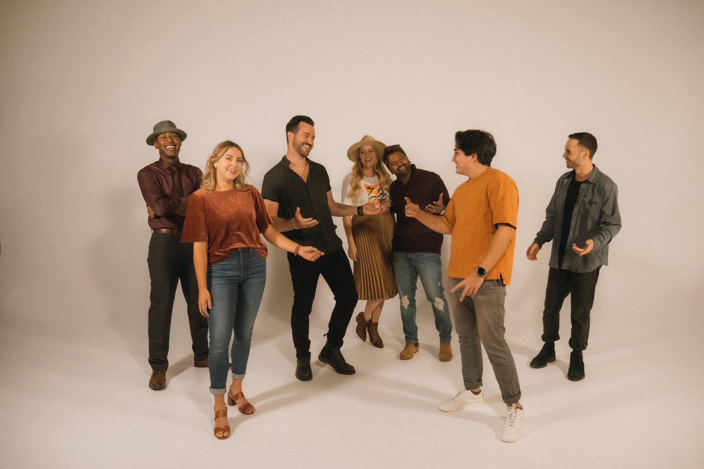A group of colleagues laughing and chatting in a studio.