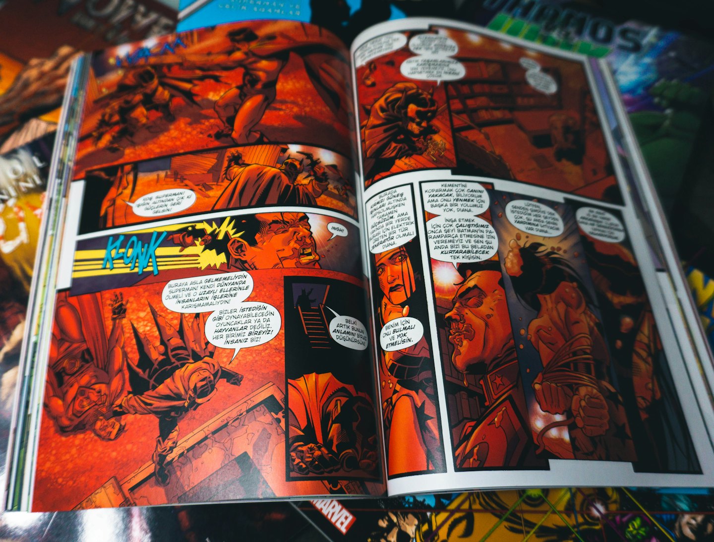 Open comic book with superhero action panels and speech bubbles.